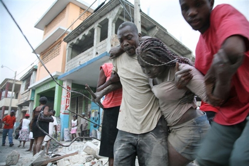 Des hommes viennent en aide  une femme prise dans les dcombres d'un immeubles  Port-au-Prince (AFP PHOTO - Lisandro SUERO)