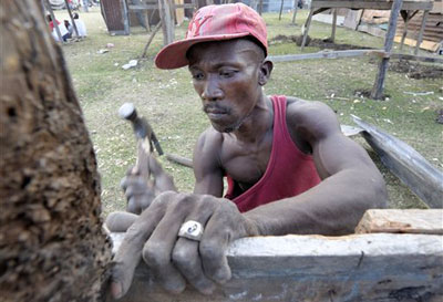 Un Hatien construit un abris temporaire pour sa famille en utilisant des matriaux de  btiments effondrs, mercredi 20 janvier 2010