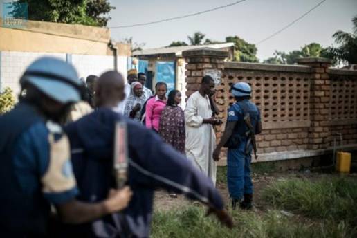 Un soldat burundais de la Minusca contrle des lecteurs de la communaut musulmane du PK-5  l'entre d'un bureau de vote  Bangui, le 14 dcembre 2015