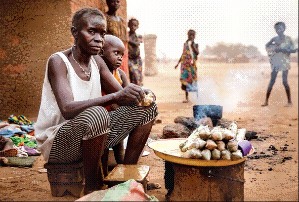 Batangafo, Prfecture de l'Ouham. Philomne Ngombe, 50 ans, mre de huit enfants, prpare  manger devant sa maison sur le site de personnes dplaces internes. OCHA / A. Surprenant